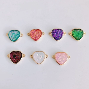 Macro shot of colorful heart-shaped gold-edged resin jewelry connectors for DIY necklaces