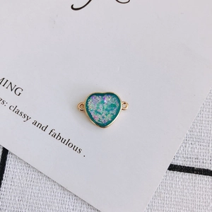 Detail of heart-shaped blue resin jewelry connector with gold edge and glitter for DIY