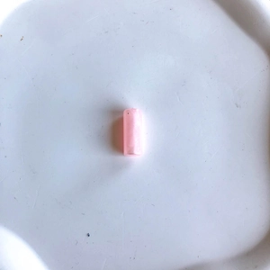 Dettaglio di perle cilindriche in resina rosa per la creazione di gioielli fai da te