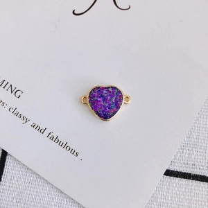 Detail of gold-edged heart charm with purple glitter resin and dual connecting loops