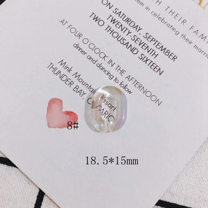 Macro detail of 18.5x15mm iridescent resin U-shape jewelry pendant on card background