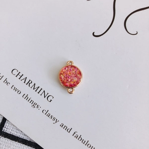 Detail eines roségoldenen Anhängers mit glitzernden rosa Steinen für DIY-Schmuck
