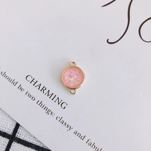 Detail eines rosa Glitzeranhängers mit Goldrand für DIY-Schmuckherstellung
