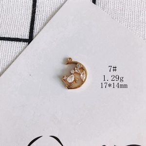 Detailed view of 17x14mm gold-plated moon pendant with bird motif on display card