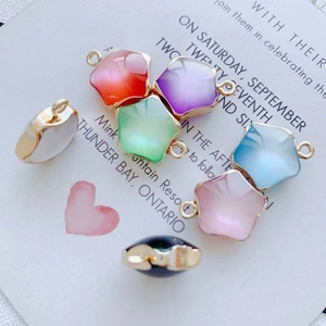 Vue détaillée de breloques étoiles en résine multicolore avec bords dorés pour bijoux DIY