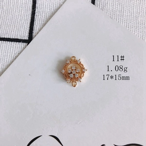 Macro detail of a 17x15mm gold-plated flower pendant with clear cubic zirconia stones