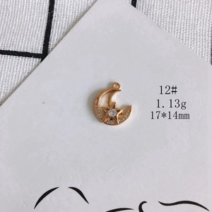 Detail of gold-plated celestial moon and star pendant with cubic zirconia settings