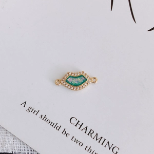Detail of gold-plated lip pendant with green opal inlay and white zircon micro-pave