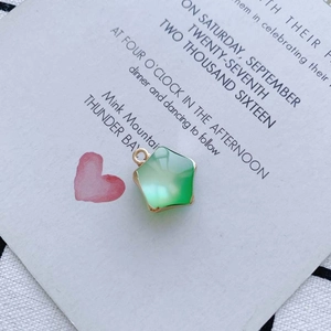 Vue macro d'un pendentif étoile en résine vert clair avec bordure dorée sur carte