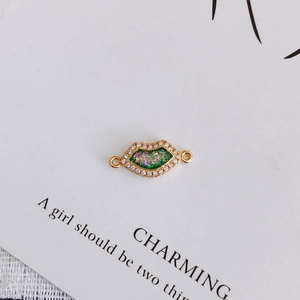 Macro detail of lip-shaped zircon pendant connector with colorful glitter and gold plating