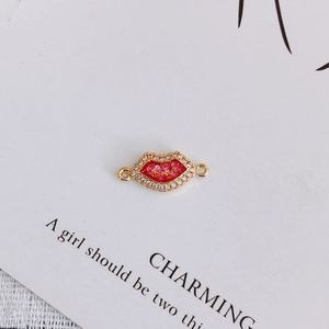 Macro detail of gold-plated red lip charm with zircon inlay for DIY jewelry making