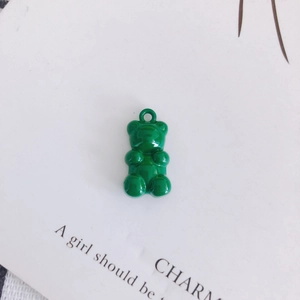 Detail view of a bright green resin gummy bear pendant with a metallic hanging loop