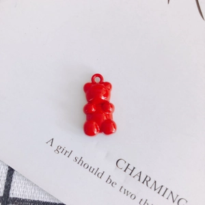 Macro shot of a red candy-colored bear pendant charm with metal ring for DIY jewelry making