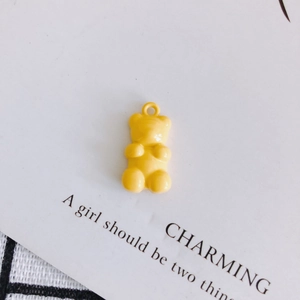 Close-up of a yellow resin gummy bear pendant with a top ring for DIY jewelry making