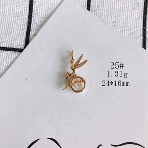 Macro detail of a 18K gold-plated fairy pendant with shimmering zircons and moving stone
