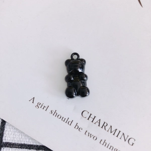 Detailed close-up of a glossy black resin bear charm with a ring for DIY jewelry making
