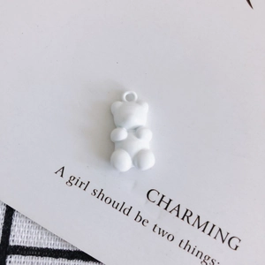 Detail of a matte white bear pendant with a top hook for DIY jewelry making and crafts