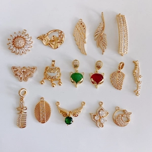 Detailed collection of 16 gold-plated jewelry pendants including locks, wings, and gems