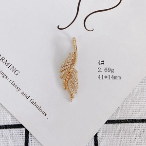Detailed macro view of a gold-plated feather pendant with sparkling zircon inlays
