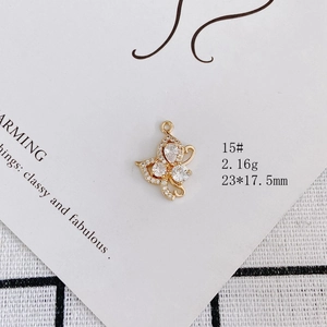 Detail view of gold-plated butterfly pendant with clear zircons on white display card