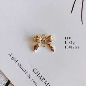 Détail du pendentif nœud doré 15x17mm avec pierre claire et deux anneaux de suspension