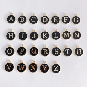 Detailed grid of 26 alphabet charms in gold metal with black enamel for DIY jewelry