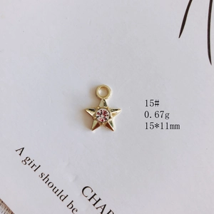 Vue macro d'un pendentif étoile pour bijoux DIY avec gemme rouge et finition dorée
