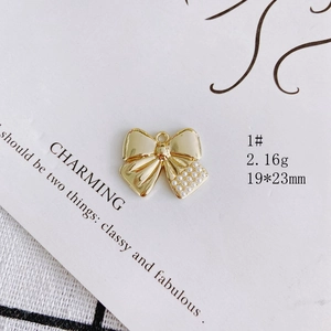 Detailed view of a gold bow pendant with pearl inlay, size 19x23mm and 2.16g weight