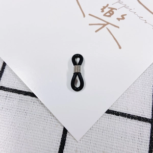 Dettaglio di passanti regolabili in silicone nero con bobine in metallo per catene da vista
