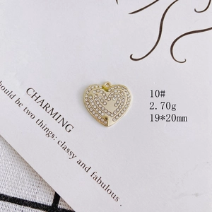 Macro detail of a 19x20mm gold heart pendant with multi-row clear rhinestones