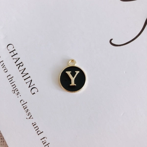 Detail of round black enamel pendant with gold letter Y charm for DIY necklace making
