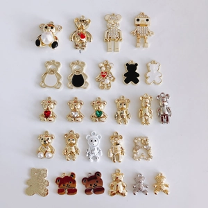 Detailed close-up of metallic bear and robot charms for DIY jewelry making