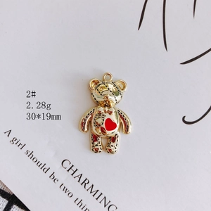 Detailed view of golden bear pendant with red heart for DIY jewelry necklaces