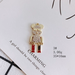 Detailed view of 35x16mm golden bear pendant with white crystals and red enamel detail