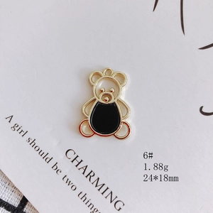 Detailed macro view of a gold-toned bear charm with black enamel for DIY jewelry making