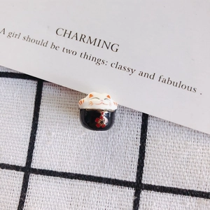 Detailed view of hand-painted ceramic lucky cat bead with floral patterns for DIY jewelry