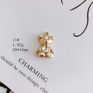 Macro shot of 20x14mm golden teddy bear pendant with a heart-shaped crystal stone