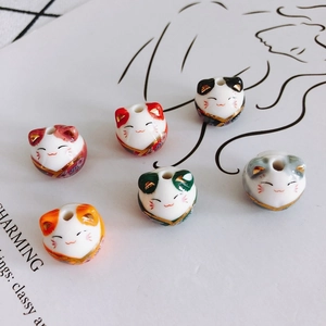 Detail view of six colorful hand-painted ceramic Maneki Neko lucky cat beads for DIY jewelry