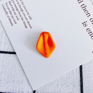 Macro detail of matte orange petal pendant with top hole for DIY earring jewelry making