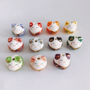 Macro view of assorted colorful ceramic Maneki Neko lucky cat beads for DIY jewelry making