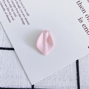 Detailed view of a pink resin flower petal charm with a hole for DIY jewelry making