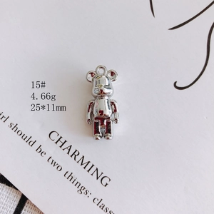Detailed view of a silver bearbrick pendant charm measuring 25x11mm on a display card
