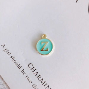 Detail of round gold Z-letter charm with light blue enamel for DIY jewelry making