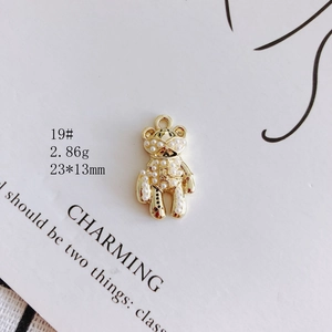 Detailed macro view of a gold-plated bear pendant set with small white pearls