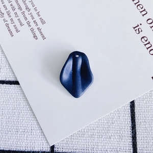 Macro detail of dark blue resin petal charm with matte finish and pre-drilled hole for DIY