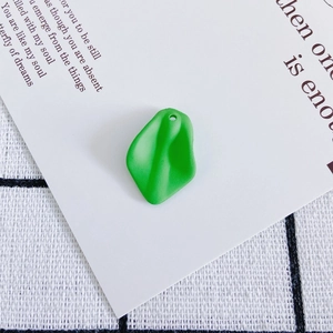 Macro detail of matte green resin petal pendant with hole for DIY jewelry making