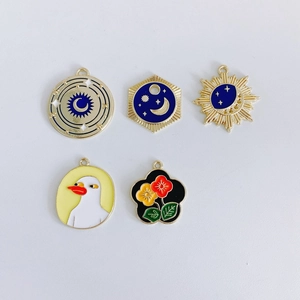 Detail of assorted enamel star, moon, and floral charms with gold plating for DIY jewelry