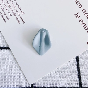 Detail view of a matte grey-blue resin petal charm with a single hole for DIY jewelry