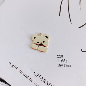 Macro shot of 18mm golden bear pendant with white enamel for DIY jewelry making