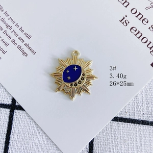 Detailed view of sun and moon alloy pendant with blue enamel and sparkling black zircons